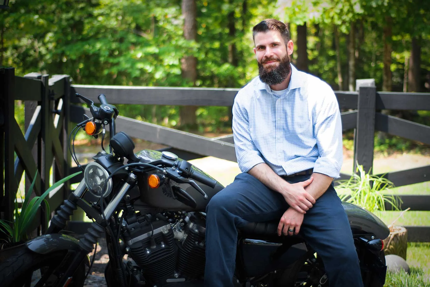 Ryan Mehaffey seated outdoors by a wooden fence